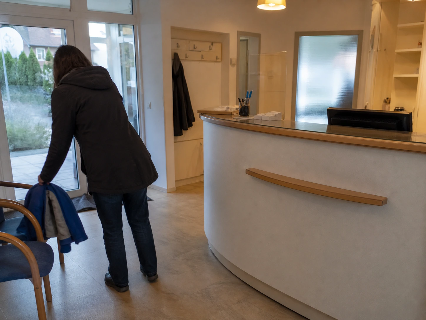 Patientin beim Ankommen im Empfangsbereich der Zahnarztpraxis
